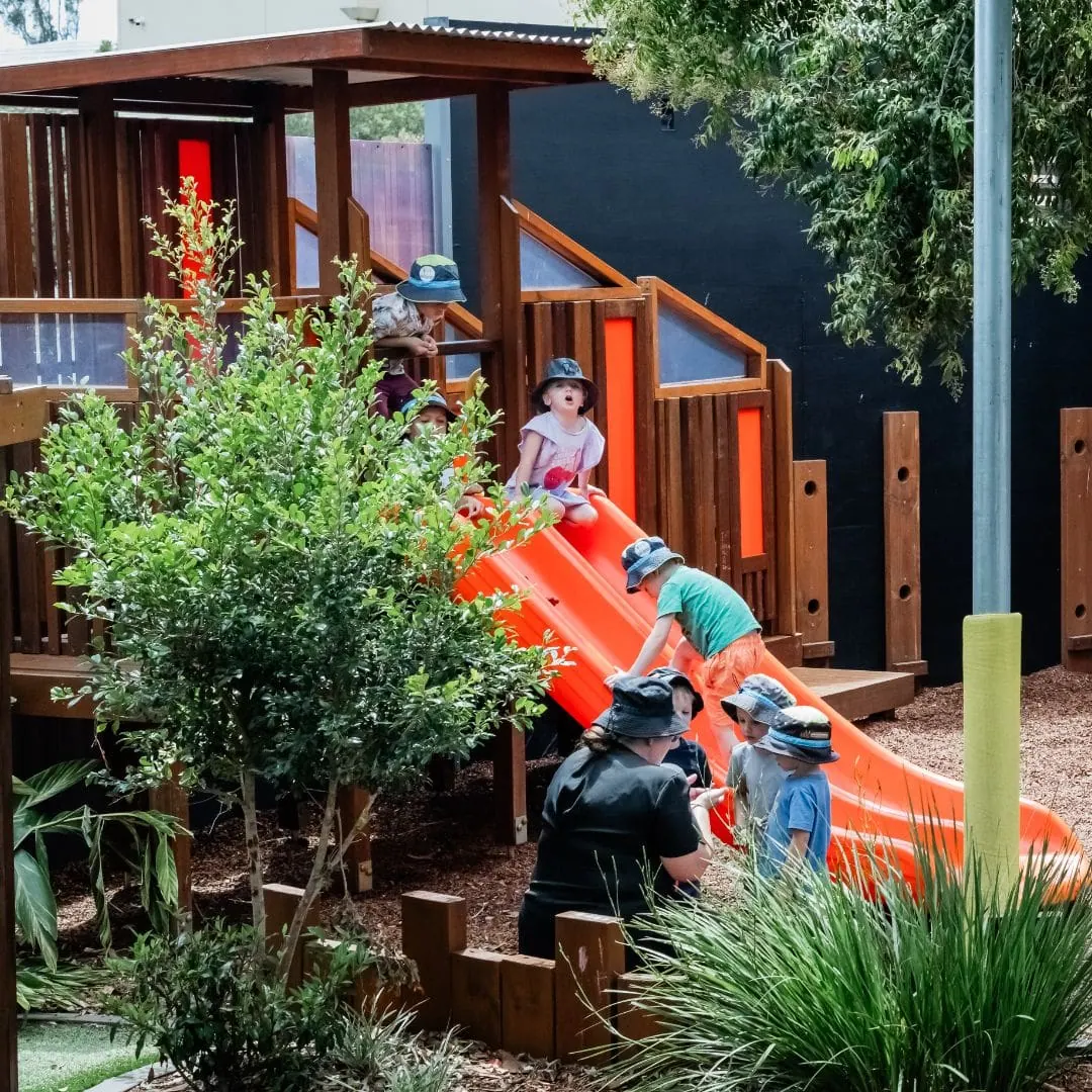 Children exploring the large adventure playground and native gardens at Natural Elements Early Learning Eagleby